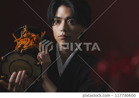身穿帶鳳頭袴的男子正在演奏日本樂器 117780600