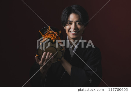 A man in a crested hakama playing a Japanese musical instrument A man in a crested hakama playing a Japanese musical instrument 117780603