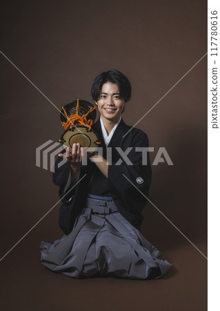 A man in a crested hakama playing a Japanese musical instrument A man in a crested hakama playing a Japanese musical instrument 117780616