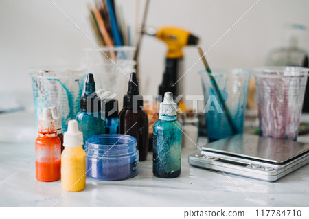 Colorful resin pigments and tools on a worktable, DIY art supplies, creative studio setup, epoxy resin project, artist workspace, crafting materials, vibrant color palette Colorful resin pigments and tools on a worktable, DIY art supplies, creative studio setup, epoxy resin project, artist workspace, crafting materials, vibrant color palette 117784710