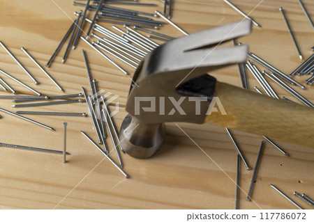 nails with small caps and an iron hammer on boards nails with small caps and an iron hammer on boards 117786072