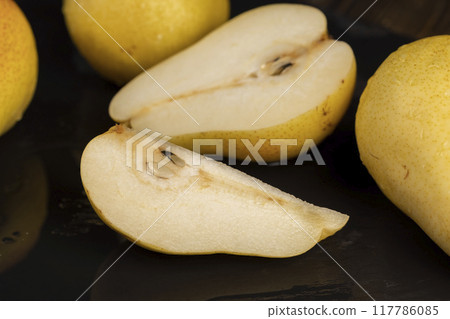 delicious yellow pears with a red side cut into pieces 117786085