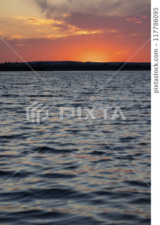 beautiful bright sunset on the lake in the summer 117786095