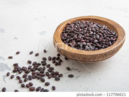 Raw organic purple beans in wooden bowl on light table. Raw organic purple beans in wooden bowl on light table. 117786621