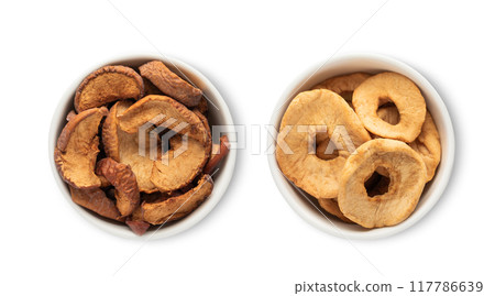 Bowl plates with sweet dried apples pieces and circles isolated on white background. 117786639