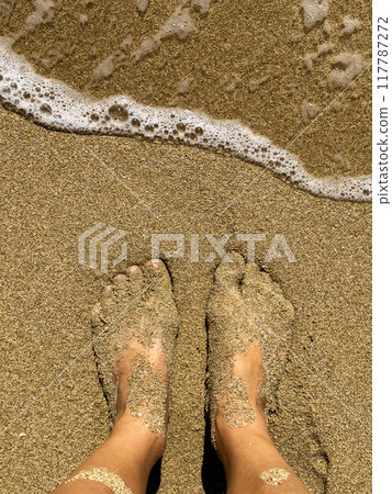 Feet on sea sand and wave with copy space, Vacation on ocean beach, Summer holiday. 117787272