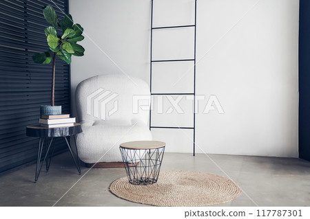 Interior design of a cozy living room with a stylish coffee table and a white armchair. Decor and personal accessories in a modern style. With a place for your design. High quality photo Interior design of a cozy living room with a stylish coffee table and a white armchair. Decor and personal accessories in a modern style. With a place for your design. High quality photo 117787301