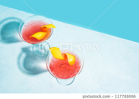 Pink martini cocktail with lemon twist 117788006