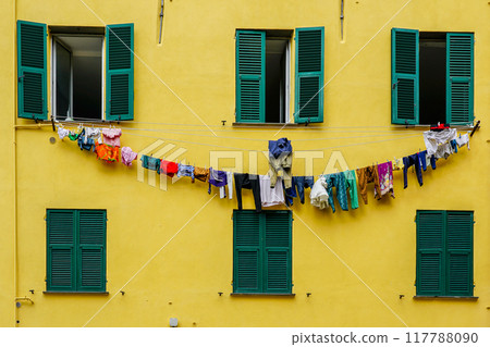 A typical Italian vintage apartment building with green shutters and laundry hanging out to dry A typical Italian vintage apartment building with green shutters and laundry hanging out to dry 117788090