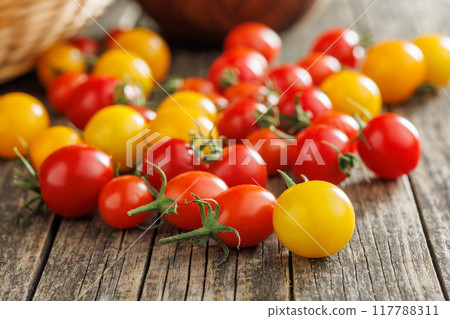 Different colorful cherry tomatoes on wooden table. 117788311