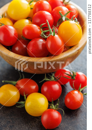 Different colorful cherry tomatoes on black table. 117788312