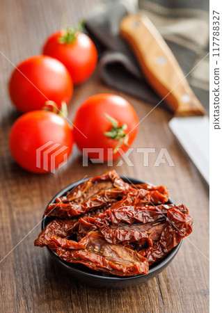 Sun dried red tomatoes on wooden table. 117788327