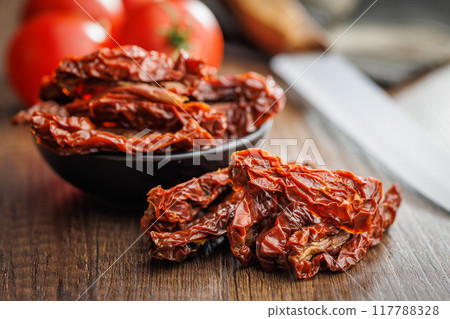 Sun dried red tomatoes on wooden table. 117788328