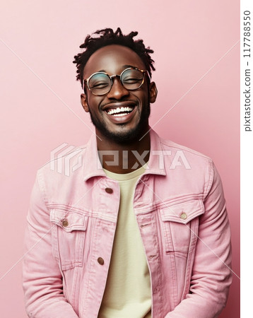 A joyful young man with curly hair smiles brightly in a casual yellow shirt 117788550