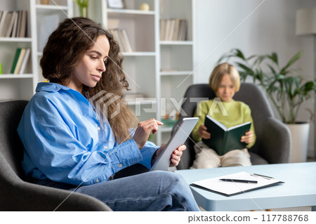 Long-haired female speech therapist working with a hard child and trying to make him feel comfortable 117788768