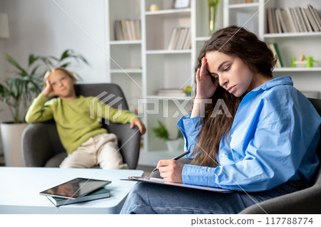 Long-haired female speech therapist working with a hard child and trying to make him feel comfortable 117788774