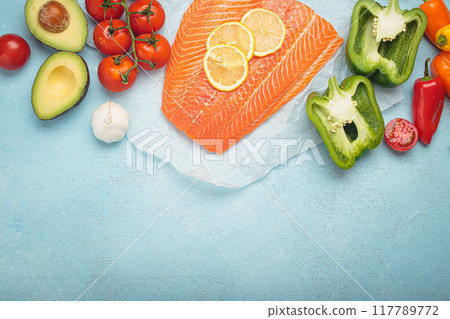 Fresh salmon fillet with vegetables arranged on blue background, space for text Fresh salmon fillet with vegetables arranged on blue background, space for text 117789772