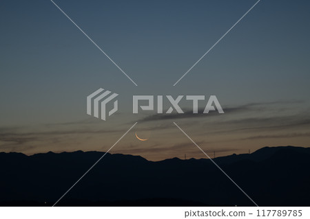 A very thin moon on the eve of the new moon over the Okuchichibu mountain range, seen from Hakushu Town, Hokuto City 117789785