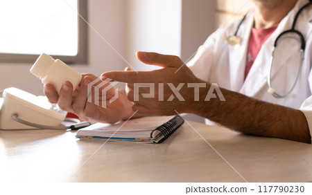 Close-up photo of a doctor giving directions about prescribed vitamins. Close-up photo of a doctor giving directions about prescribed vitamins. 117790230