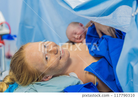 Baby on mother's chest immediately after birth in a hospital. The mother and newborn share a tender moment, emphasizing the bond and emotional connection. The medical staff ensures a safe and caring Baby on mother's chest immediately after birth in a hospital. The mother and newborn share a tender moment, emphasizing the bond and emotional connection. The medical staff ensures a safe and caring 117790310