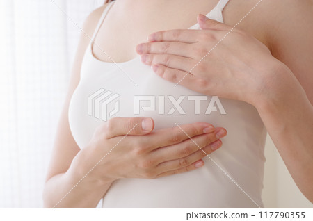Woman doing self-examination for breast cancer 117790355