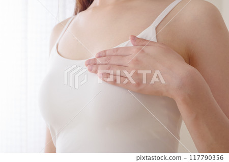 Woman doing self-examination for breast cancer 117790356