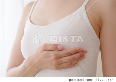 Woman doing self-examination for breast cancer 117790358