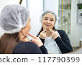 Skincare, mirror and woman popping acne on face with hands, dirt or scar on skin. Dermatology, facial wellness and girl in bathroom to squeeze pimple, checking reflection or morning routine 117790399