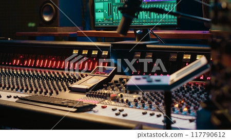 Control room with technical equipment and music recording software, professional studio editing and producing tracks. Audio console with moving faders and colored meters, high quality sounds. 117790612