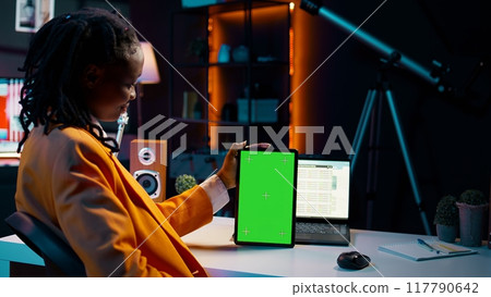 University student looking at greenscreen on tablet learning to use cash plan software, studying business and finances with online classes. Looks at copyspace, conducting data analysis. Camera B. University student looking at greenscreen on tablet learning to use cash plan software, studying business and finances with online classes. Looks at copyspace, conducting data analysis. Camera B. 117790642