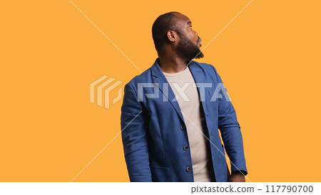 Smiling man having friendly conversation with friend sitting off camera, isolated over studio background. BIPOC person having fun catching up with mate, having lively discussion, camera B Smiling man having friendly conversation with friend sitting off camera, isolated over studio background. BIPOC person having fun catching up with mate, having lively discussion, camera B 117790700