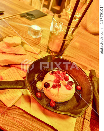 Cheese camembert with cranberries and honey in a frying pan on a wooden table Cheese camembert with cranberries and honey in a frying pan on a wooden table 117791014