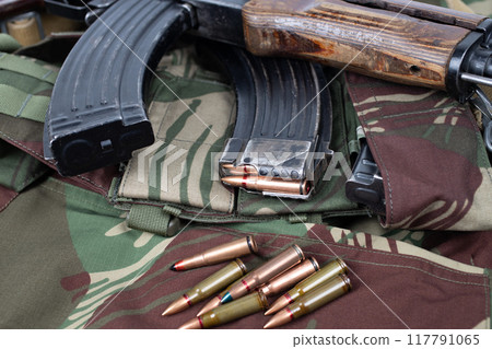 AK assault rifle on camo uniform background 117791065