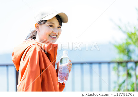 Young woman with plastic bottle for hydration 117791702