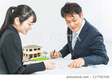 微笑的商人和婦女在設計辦公室開會 微笑的商人和婦女在設計辦公室開會 117792540