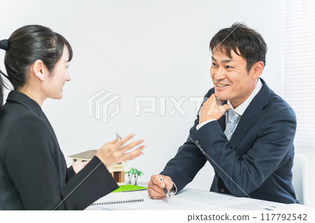 微笑的商人和婦女在設計辦公室開會 微笑的商人和婦女在設計辦公室開會 117792542