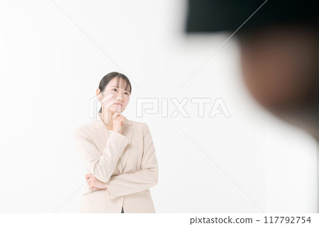 A woman in a suit with a thinking expression 117792754