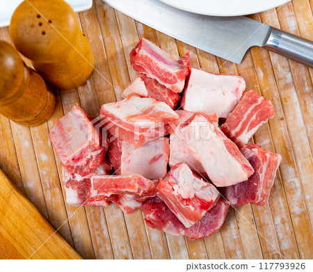 Unprepared pork ribs chopped on table and ready-to-cook 117793926