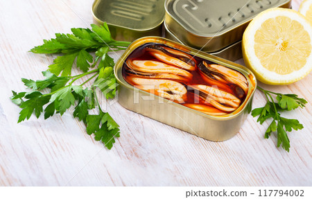 Sea pickled mussels in open tin can served with greens and lemon Sea pickled mussels in open tin can served with greens and lemon 117794002