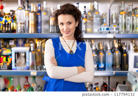 Woman works as salesperson in alcohol department of Russian store. Woman works as salesperson in alcohol department of Russian store. 117794132