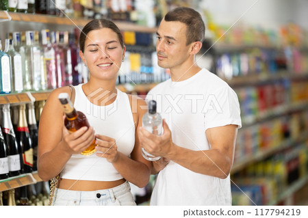 Couple of men and women choosing whiskey and vodka Couple of men and women choosing whiskey and vodka 117794219