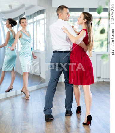 Couple in stage costumes learns waltz dancing during individual lesson Couple in stage costumes learns waltz dancing during individual lesson 117794236