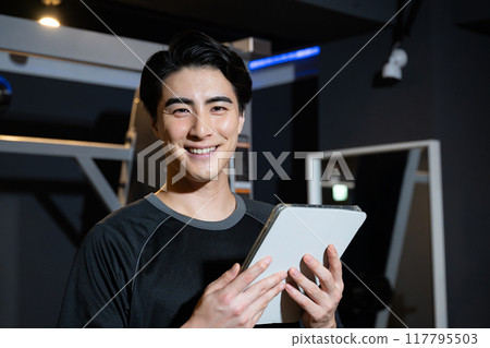 Training gym and personal trainer with tablet looking at camera Training gym and personal trainer with tablet looking at camera 117795503