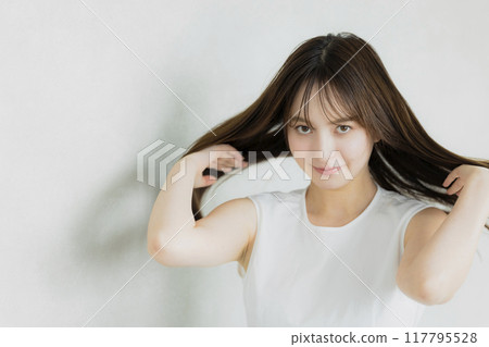 A woman touching her hair 117795528