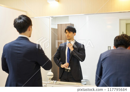 A man getting ready in a restroom 117795684