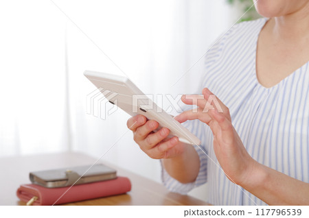 中年婦女用計算機算錢 中年婦女用計算機算錢 117796539