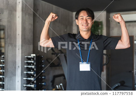 A middle-aged man who works as a personal trainer, instructor, or staff member at a gym. A middle-aged man who works as a personal trainer, instructor, or staff member at a gym. 117797558