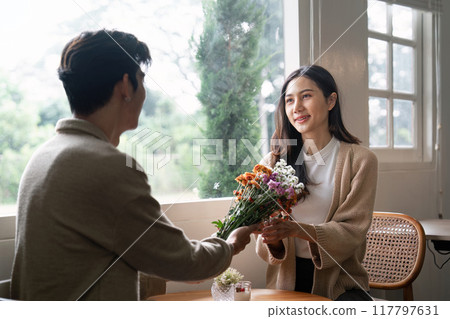 Couple Sharing a Bouquet Near Sunlit Window Couple Sharing a Bouquet Near Sunlit Window 117797631