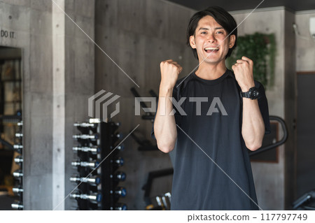 Young Asian man personal trainer instructor working at a sports gym 117797749