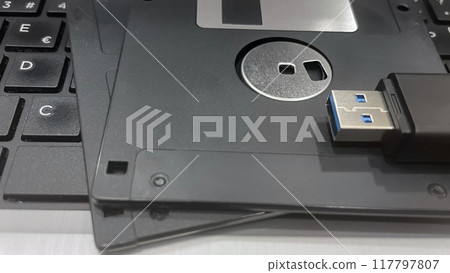 From Past to Present. The Evolution of Data Storage. The striking visual comparison between an old black floppy disk and today's blue USB stick symbolizes the rapid advancement of data storage technol From Past to Present. The Evolution of Data Storage. The striking visual comparison between an old black floppy disk and today's blue USB stick symbolizes the rapid advancement of data storage technol 117797807